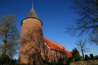 Foto der Hollerner Kirche mit dem rundgemauerten Wehrturm aus Backsteinen